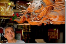 Masanobu Sonoda sob um releveode dragão em sua loja